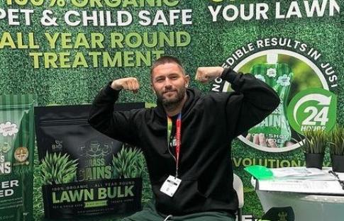 Man at Grass Gains trade show booth.