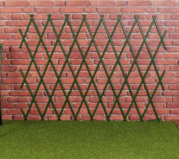 Green privacy screen against a brick wall.