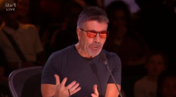 Screenshot of Simon Cowell speaking into a microphone.