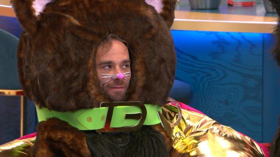 A man in a brown cat costume on a reality television show.