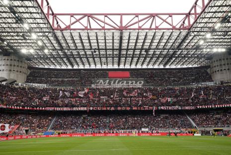 Interior view of the San Siro stadium in Milan, filled with spectators.