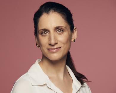 Headshot of a woman wearing a white shirt.