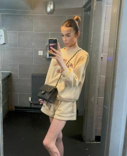 A young woman taking a selfie in a restroom.