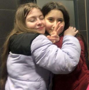 Two teenage girls hugging.