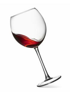 Glass of red wine tilted on its side.