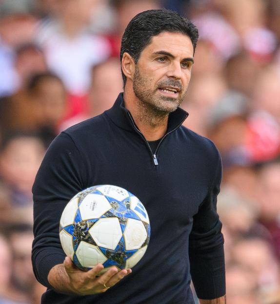 Mikel Arteta, Arsenal manager, holding a soccer ball.