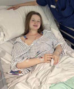 Teenage girl recovering in hospital bed.