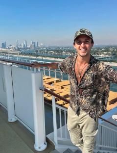Man on cruise ship overlooking Miami skyline.