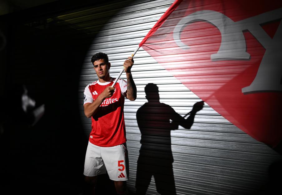 Piero Hincapie in Arsenal kit holding team flag.