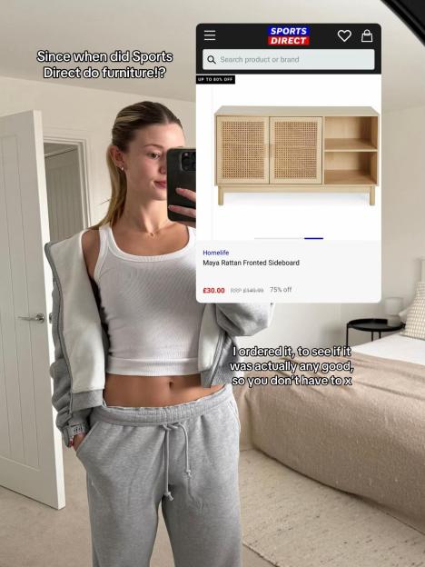 A woman holding a phone showing a Sports Direct product page for a Homelife Maya Rattan Fronted Sideboard.