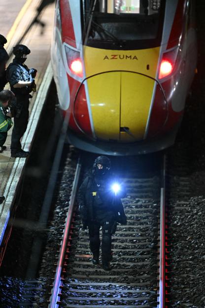 Police officers search the track in front of an LNER Azuma train at Huntingdon Station following a stabbing on a train.