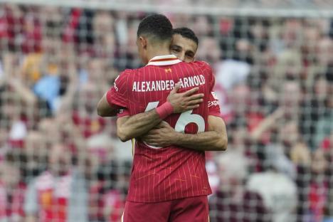 Mohamed Salah hugging Trent Alexander-Arnold after scoring a goal.