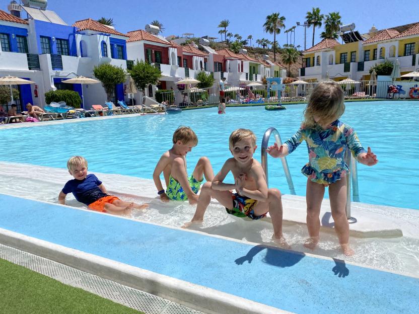 Four children playing in a pool.