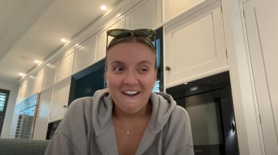 Woman in a grey hoodie describing a botched botox treatment.