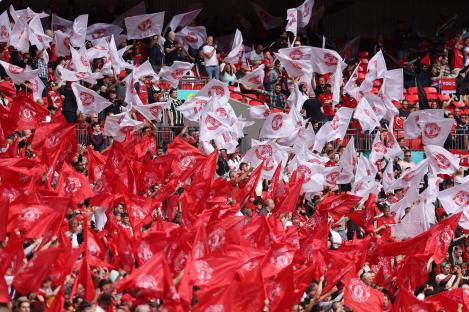 Manchester United fans waving flags at a stadium.