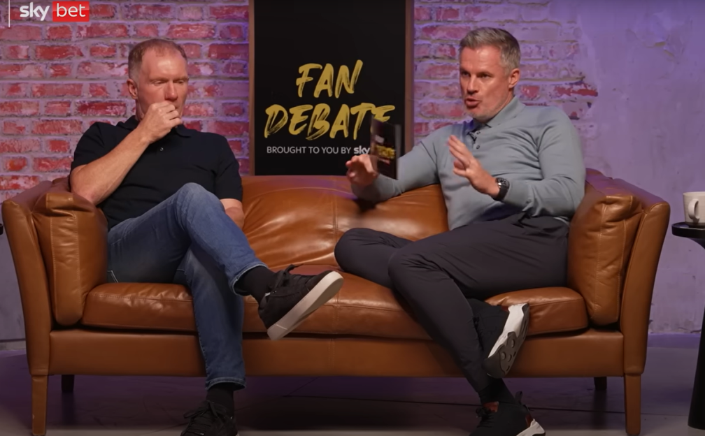 Two men sitting on a couch discussing a "Fan Debate" segment.