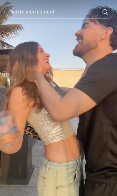 Laughing couple embracing outdoors.