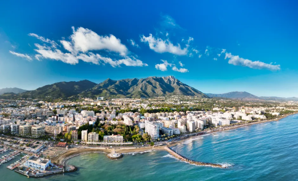 Aerial view of a coastal city with mountains in the background.