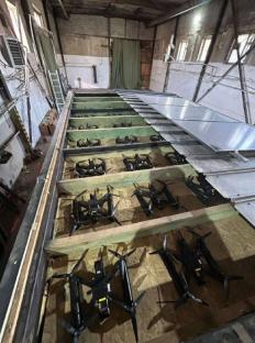 Many drones inside a warehouse, prepared for a special operation.