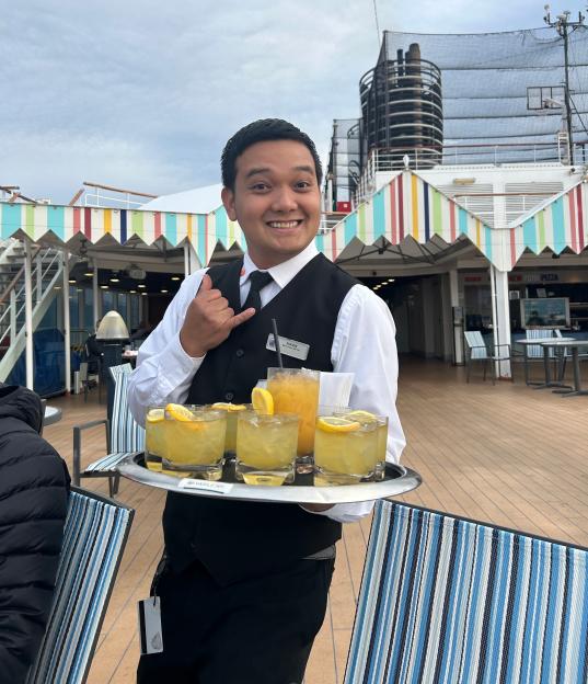 Waiter on Holland America Line's Nieuw Amsterdam serving drinks.