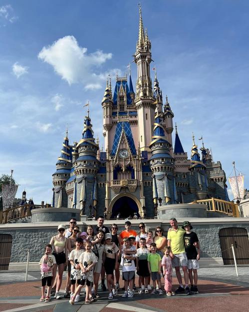 Large family posing in front of Cinderella Castle at Disney World.