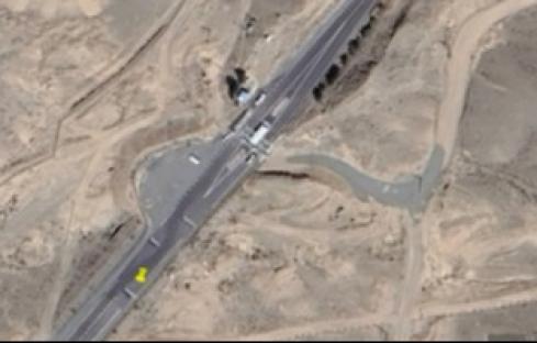 Aerial view of a highway interchange under construction in a desert landscape.