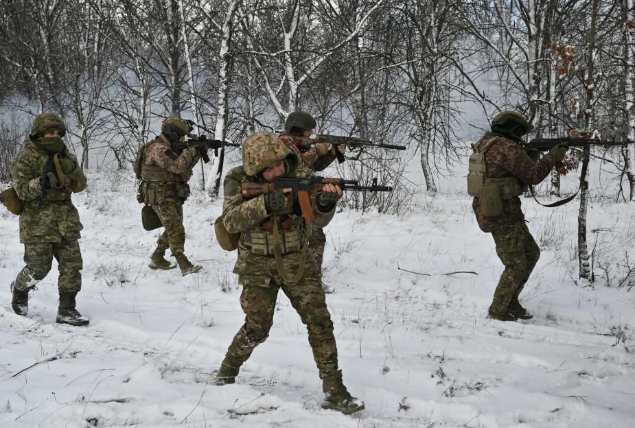 Ukrainian soldiers conducting a field training exercise in a snowy forest.