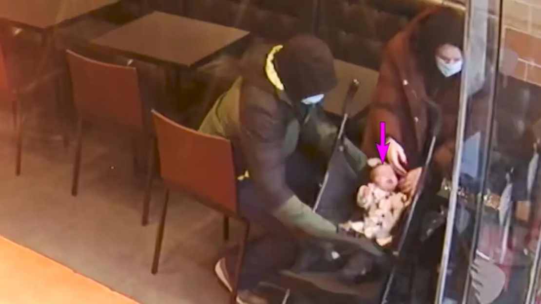 Surveillance image of a couple with a baby in a stroller at a cafe.
