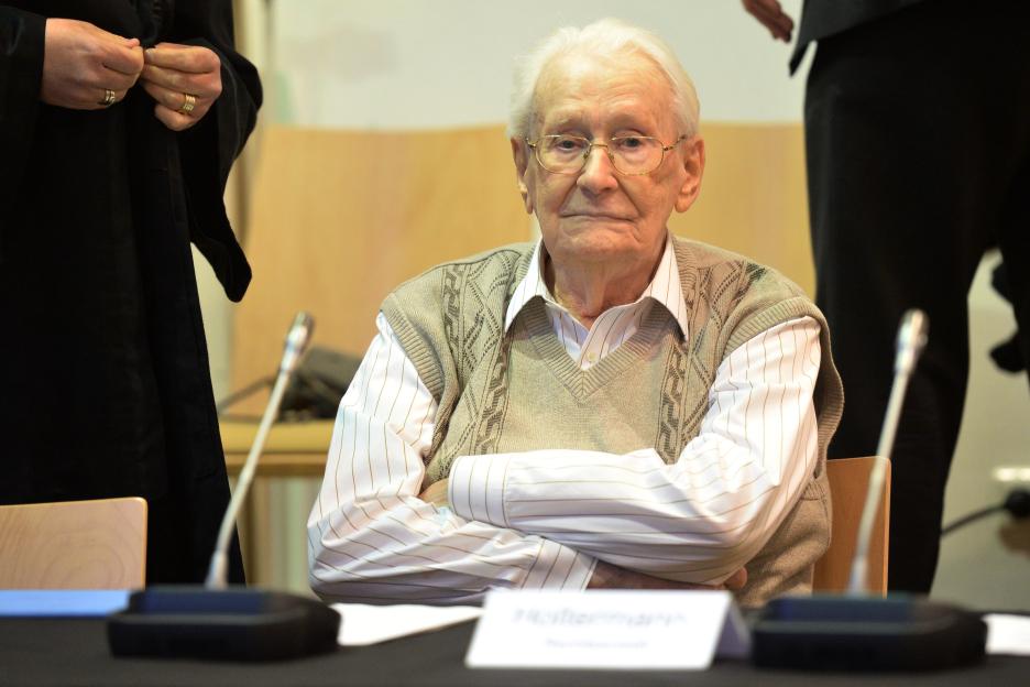 Oskar Groening, dubbed the "bookkeeper of Auschwitz", looks over his shoulder in a courtroom.
