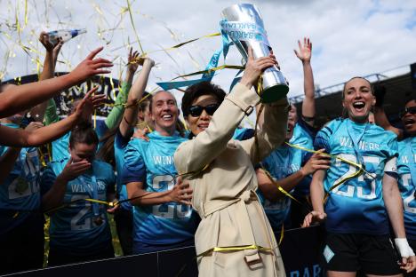Michele Kang, owner of London City Lionesses, holding the Barclays Women's Championship trophy with her team.