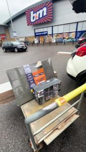 Bathroom supplies on a cart outside a B&M store.