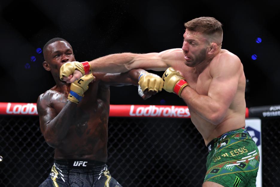 two men are fighting in a ring and one of them is wearing ufc shorts