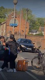 Two men fighting on a city street.