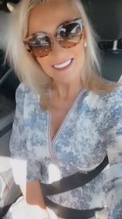 Screenshot of a woman in a car showing off her new teeth.