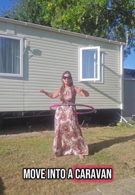 Woman hula hooping in front of a caravan.