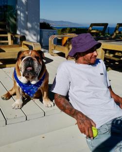 Lewis Hamilton and his bulldog Roscoe on a patio.