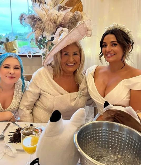 A bride, her mother, and sister at a wedding reception.