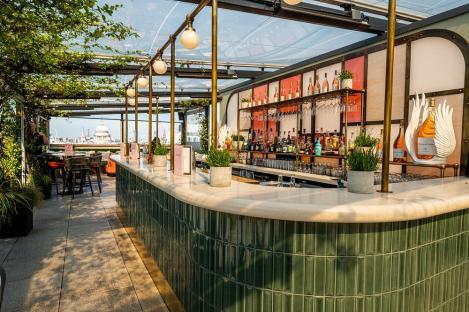 Rooftop bar with green tile and a view of the city.