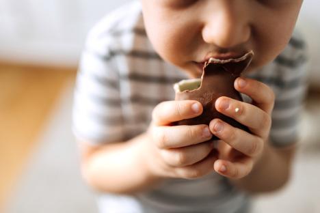 Close up of cute little boy eating chocolate