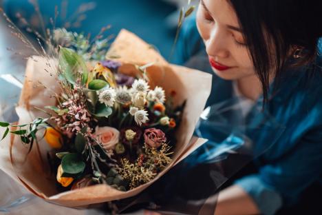 Aerial view of young woman receiving flower bouquet delivery on Valentine’s day. Online dating concept. Long distance relationship concept. Remote love.
