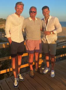 Mark Wright with his father and brother on a beach boardwalk.