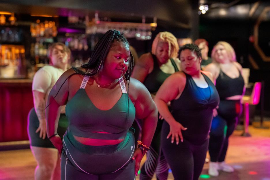 Group of plus-size women exercising in a bar.