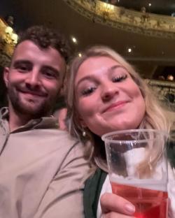 Selfie of Harriet Cowan and a man at a theatre.