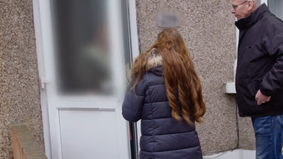 A girl and a man outside a house.
