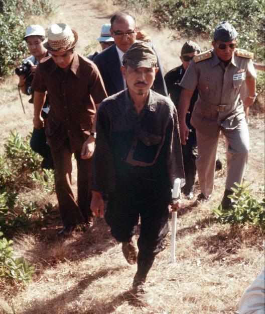 A Japanese soldier walks out of the jungle, escorted by Philippine officials, after hiding there for three decades following World War II.