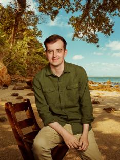 Man sitting on a chair on a beach.