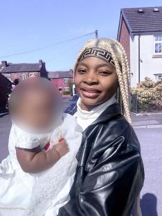 A woman holding her baby while on a bus.