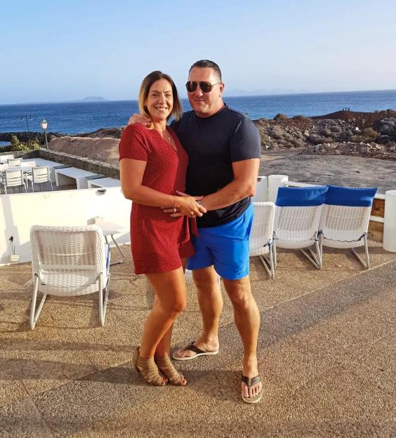 Couple embracing outdoors by the ocean.
