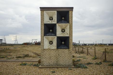 Checkerboard sound mirror on a shingle beach.