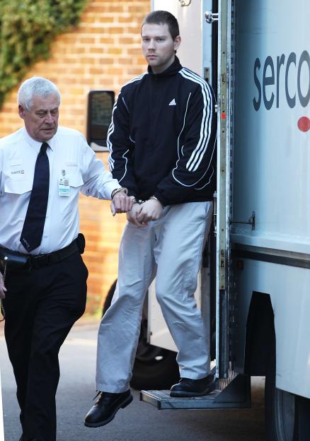 Christopher Hunnisett, handcuffed and in an Adidas jacket, exits a Serco vehicle, escorted by a guard.